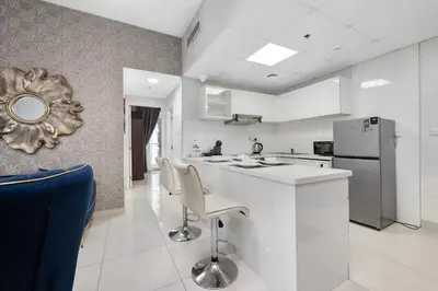 a white kitchen with a counter and a refrigerator at Spacious 2 Bedroom Apartment in JBR in Dubai