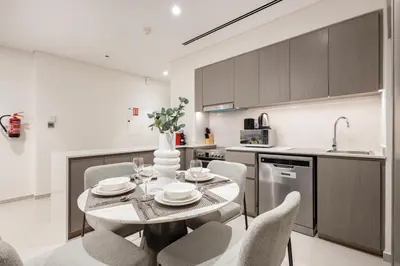 a kitchen and dining room with a table and chairs at Grande Residence, Downtown - 1 Bedroom Apartment - Allsopp & Allsopp in Dubai