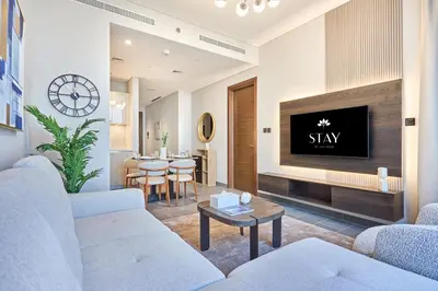 a living room with a couch and a tv at STAY BY LATINEM Luxury 1BR Holiday Home CB 2601 Near Burj Khalifa in Dubai