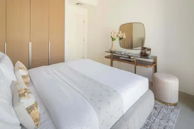 a bedroom with a white bed and a mirror at Frank Porter - Grove at Creek Beach Building in Dubai