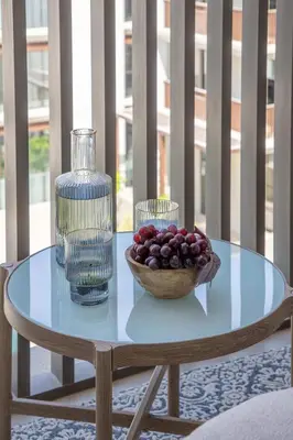 a glass table with a bowl of fruit and a vase at Frank Porter - Grove at Creek Beach Building in Dubai