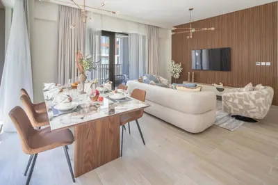 a living room with a table and a couch at Frank Porter - Grove at Creek Beach Building in Dubai