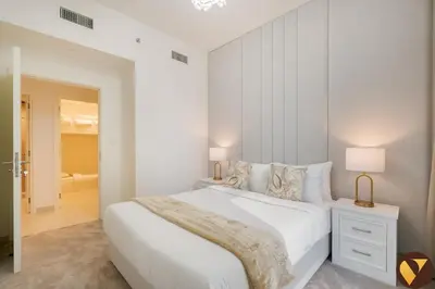 a white bedroom with a large white bed and a room at Vogue Downtown Burj Crown near Burj Khalifa and Dubai Mall, Three Bedroom plus Kids Room Apartment with Large Balcony and Skyline view, Access to all Amenities in Dubai