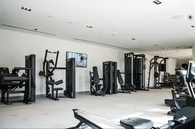 a gym with rows of treadmills and machines at Vogue Downtown Burj Crown near Burj Khalifa and Dubai Mall, Three Bedroom plus Kids Room Apartment with Large Balcony and Skyline view, Access to all Amenities in Dubai