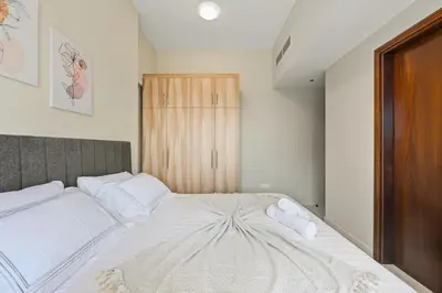 a bedroom with a large white bed with white pillows at Modern Luxury 2BR Apartment In Dubai Sports City in Dubai