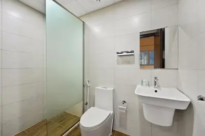 a white bathroom with a toilet and a sink at Modern Luxury 2BR Apartment In Dubai Sports City in Dubai