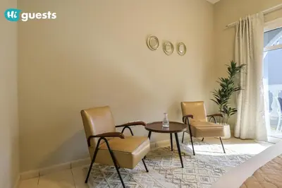 a dining room with chairs and a table and a window at HiGuests - Experience Luxury 1BR Living at Autumn-1A in JVC in Dubai