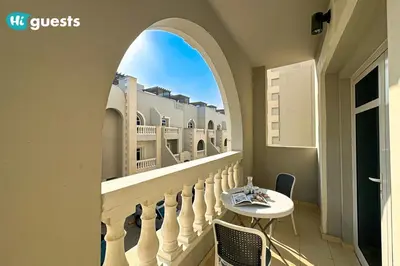 a balcony with an archway and a table and chairs at HiGuests - Experience Luxury 1BR Living at Autumn-1A in JVC in Dubai