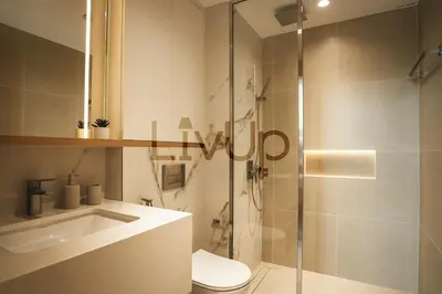 a bathroom with a shower and a toilet and a sink at Stylish 1-Bedroom in JVC with large balcony in Dubai