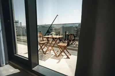 a view of a table and chairs on a balcony at Stylish 1-Bedroom in JVC with large balcony in Dubai