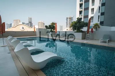 a swimming pool on the roof of a building at Stylish 1-Bedroom in JVC with large balcony in Dubai