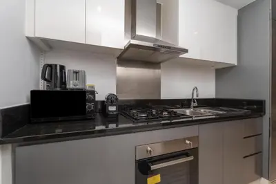 a kitchen with a sink and a stove top oven at GuestReady - Studio l Canal Views | Business Bay in Dubai