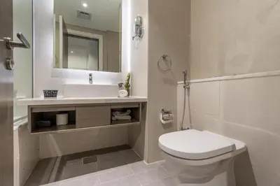 a bathroom with a toilet and a sink and a mirror at GuestReady - Studio l Canal Views | Business Bay in Dubai