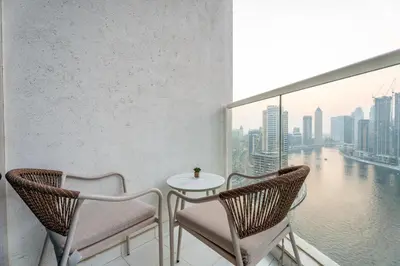 a balcony with a table and chairs and a large window at GuestReady - Studio l Canal Views | Business Bay in Dubai