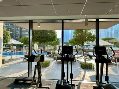 a gym with treadmills in front of a large window at Boulevard Heights Downtown Perfect Location High floor Luxury Apartment! in Dubai