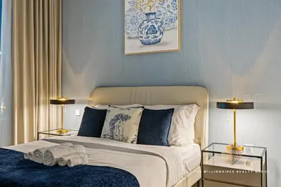 a bedroom with a bed with blue and white at Burj Khalif View from Bedroom - Millionaire Residence in Business Bay Dubai in Dubai