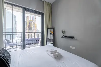 a bedroom with a white bed and a large window at GuestReady - 1BR l Canal View | Business Bay in Dubai