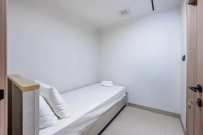 a bed in a room with white walls at Skyview Luxe 4BR - Elegant Sea & Ain Dubai View in Dubai