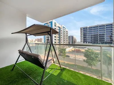a hammock on a balcony with a view of a city at Sleek 1BR Apt Free Pool & Gym Access in Dubai
