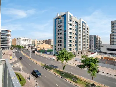 a view of a city street with a tall building at Sleek 1BR Apt Free Pool & Gym Access in Dubai