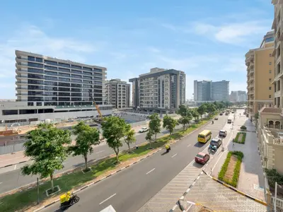 a street in a city with cars and buildings at Sleek 1BR Apt Free Pool & Gym Access in Dubai