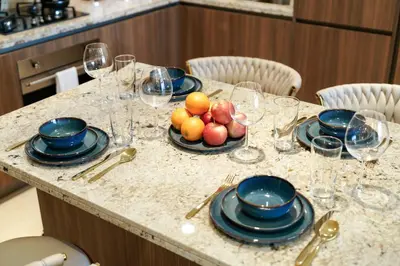a table with glasses and plates of fruit on it at Classy and Chic 2BR in Downtown with Burj Khalifa View in Dubai