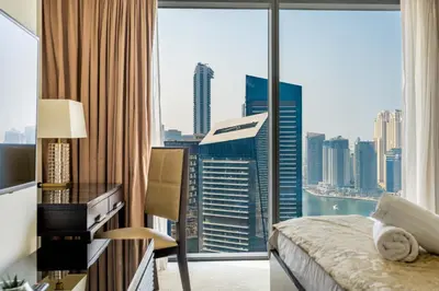 a bedroom with a large window with a view of the city at Marina Views & 5-Star Comfort Dubai Marina in Dubai
