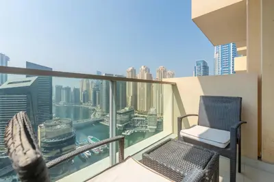 a balcony with a chair and a view of the city at Marina Views & 5-Star Comfort Dubai Marina in Dubai