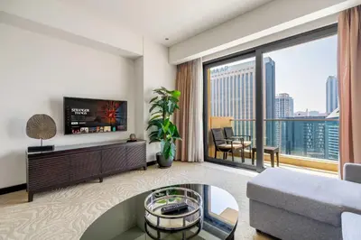 a living room with a tv and a large window at Marina Views & 5-Star Comfort Dubai Marina in Dubai
