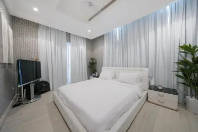 a bedroom with a large white bed and a television at World Class Luxurious 5 BDR Villa In Palm Jumeriah in Dubai