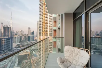 a chair on a balcony with a view of the city at GuestReady - Studio | Canal View & Burj Khalifa in Dubai