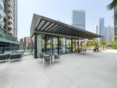 a glass building with a table and chairs at GuestReady - Studio | Canal View & Burj Khalifa in Dubai