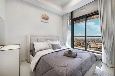 a bedroom with a bed and a large window at Cozy 2BR Aykon City Near Downtown - Pool and Gym in Dubai