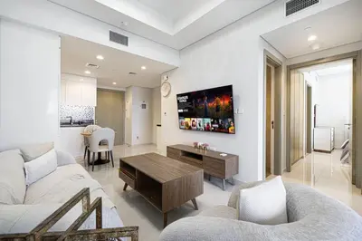 a living room with a couch and a table at Cozy 2BR Aykon City Near Downtown - Pool and Gym in Dubai