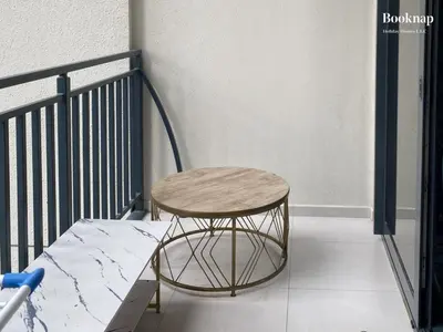 a small stool on a balcony with a table at Luxury Stay at Zada Tower 1BHK in Business Bay in Dubai