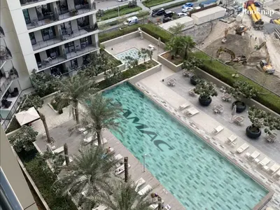 an overhead view of a large swimming pool with palm trees at Luxury Stay at Zada Tower 1BHK in Business Bay in Dubai