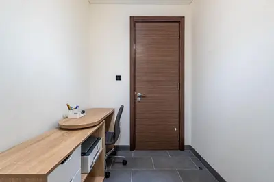 an office with a wooden desk and a door at Sobha Crest Luxury Apartments in Dubai