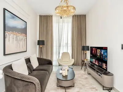 a living room with a couch and a tv at 1 BR 10 mins to Burj Khalifa with Cinema,Gym & Pool in Dubai