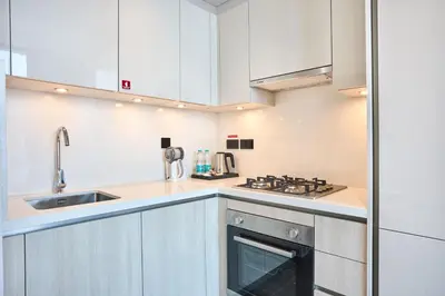 a kitchen with white cabinets and a sink and a stove at STAY BY LATINEM Luxury 1BR Holiday Home CB 3602 Near Burj Khalifa in Dubai