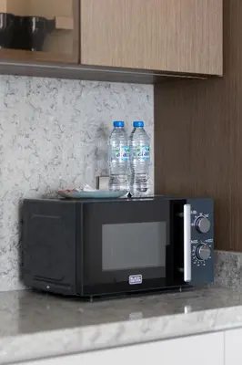 two bottles of water sitting on top of a microwave at 1BR Sea View at Grand Bleu - Emaar Beachfront in Dubai