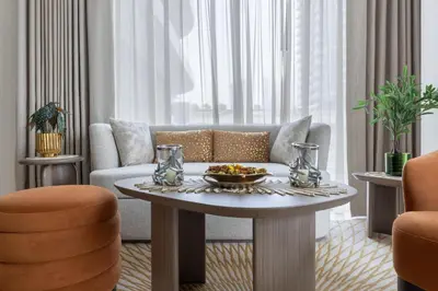 a living room with a table and a couch at 1BR Sea View at Grand Bleu - Emaar Beachfront in Dubai