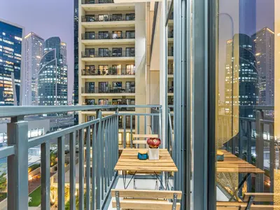 a table on a balcony with a view of a city at Savis Homes - Zada Tower Luxury Escape - Close to Dubai Mall & Burj Khalifa in Dubai