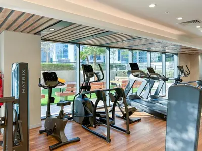 a gym with treadmills and elliptical machines at Savis Homes - Zada Tower Luxury Escape - Close to Dubai Mall & Burj Khalifa in Dubai
