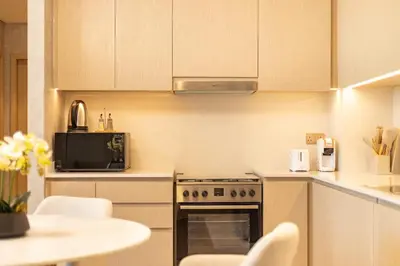 a kitchen with a stove and a table with chairs at Stunning Burj View High Floor EB in Dubai