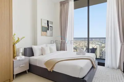 a bedroom with a large bed with a large window at Modern Studio on High Floor with Stunning City Views near Circle Mall and Community Parks - Binghatti Tulip, JVC - by Deluxe Holiday Homes in Dubai