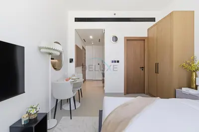 a bedroom with a bed and a bathroom with a sink at Modern Studio on High Floor with Stunning City Views near Circle Mall and Community Parks - Binghatti Tulip, JVC - by Deluxe Holiday Homes in Dubai