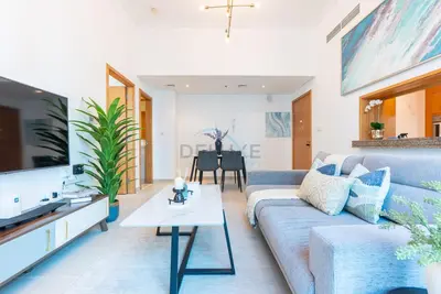 a living room with a couch and a tv at Next to Marina Canal 1BR, Easily Accessible from the Tram, a Short Stroll to Marina Beach and The Walk, Beauport X1, Dubai Marina - by Deluxe Holiday Homes in Dubai