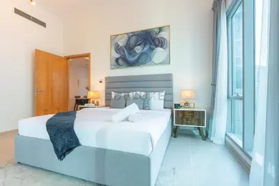 a bedroom with a large white bed and a window at Next to Marina Canal 1BR, Easily Accessible from the Tram, a Short Stroll to Marina Beach and The Walk, Beauport X1, Dubai Marina - by Deluxe Holiday Homes in Dubai