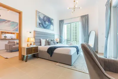 a bedroom with a bed and a chair and a mirror at Next to Marina Canal 1BR, Easily Accessible from the Tram, a Short Stroll to Marina Beach and The Walk, Beauport X1, Dubai Marina - by Deluxe Holiday Homes in Dubai