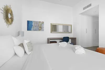 a white bedroom with a large white bed at VayK - Luxurious 2BR on the Palm with Private Beach Access in Dubai